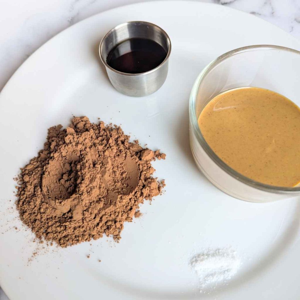 cocoa powder, peanut butter, and maple syrup on a plate