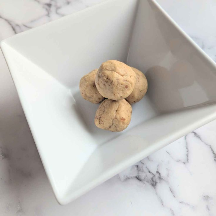 3 Chickpea protein balls stacked up in a square white bowl